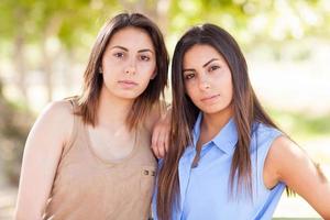 retrato de duas lindas irmãs gêmeas étnicas ao ar livre. foto