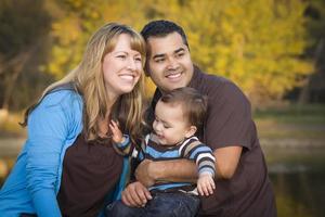 família étnica de raça mista feliz brincando no parque foto