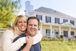 casal feliz se abraçando na frente de casa foto