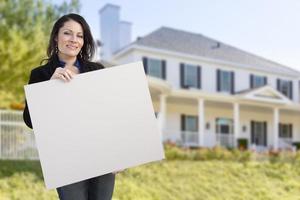 mulher hispânica segurando placa em branco na frente de casa foto