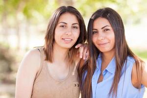retrato de duas lindas irmãs gêmeas étnicas ao ar livre. foto