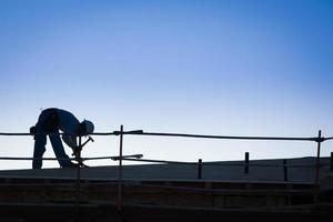 silhueta de trabalhadores da construção civil no telhado do prédio foto