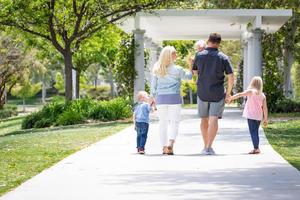 jovem família caucasiana passeando no parque foto