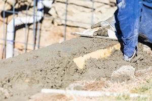 trabalhador da construção civil piscina trabalhando com flutuador de madeira em concreto molhado foto