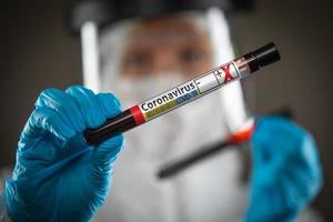 médica ou enfermeira segurando tubo de ensaio de sangue rotulado como positivo para doença de coronavírus covid-19 foto