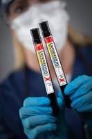 trabalhadora de laboratório segura tubos de ensaio de sangue rotulado como doença de coronavírus covid-19 foto