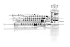 frasco de vacina coronavírus covid-19 e várias seringas na superfície reflexiva foto