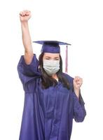 graduando-se usando máscara facial médica e boné e vestido torcendo isolado em um fundo branco foto
