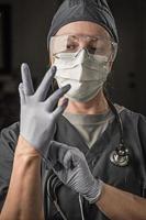 médica ou enfermeira usando jaleco, máscara protetora e óculos de proteção foto