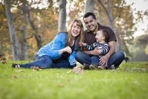 feliz família étnica de raça mista brincando com bolhas no parque foto