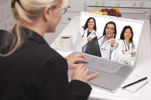 mulher usando laptop vendo três médicos com polegares para cima foto