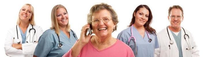 mulher sênior feliz usando telefone celular e médicos atrás foto