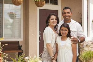 pequena família hispânica na frente de sua casa foto
