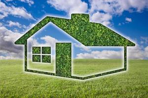 ícone de casa de grama verde sobre campo, céu e nuvens foto