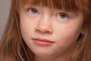 retrato divertido de uma adorável garota ruiva em cinza foto