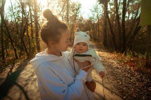 bela jovem mãe com bebê no outono foto