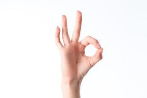 mão feminina mostrando o gesto de entrar em contato com o dedo indicador e o polegar é isolado em um fundo branco foto