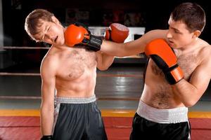 dois homens estão lutando boxe no ringue foto