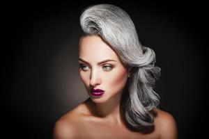jovem mulher com cor de cabelo grisalho e bela maquiagem em estúdio foto