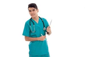jovem médico de uniforme com estetoscópio posando isolado no fundo branco foto