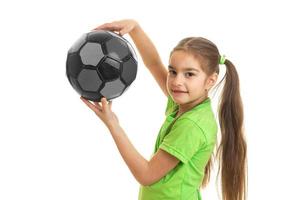 retrato de uma linda garotinha com a bola nas mãos de um close-up foto