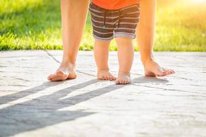 pés de mãe e bebê dando passos ao ar livre foto