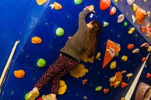 menina subindo no ginásio de escalada ao ar livre foto