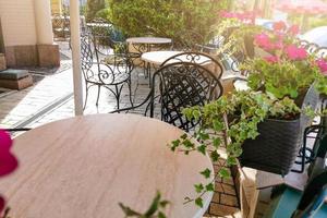 terraço aconchegante em uma rua italiana com cadeiras brancas e flores brancas foto