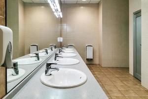 pias modernas com espelho em banheiro público foto
