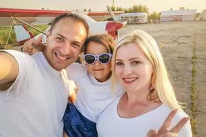 família feliz passando bons momentos juntos na praia, tirando selfie foto