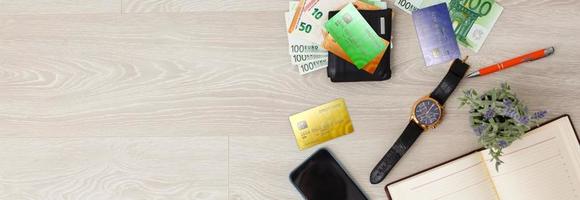 telefone celular e cartão de crédito, chave e carteira na mesa de madeira marrom, acessórios do empresário. foto