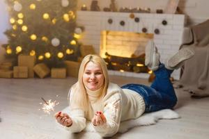 retrato de jovem atraente celebrando mulher segurando brilhos, natal foto