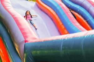 uma criança alegre brinca em um castelo inflável foto