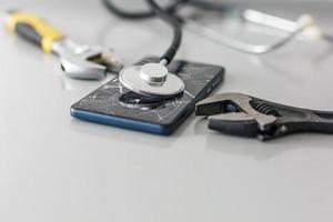 conserto de celular. peças e ferramentas de smartphone para recuperação, reparo de telefone de foco seletivo e conceito de serviço smartphone sendo diagnosticado com um estetoscópio foto