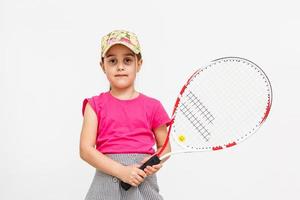 menina bonitinha com raquete de tênis em fundo branco. foto