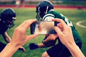 homem de apostas através de seu telefone inteligente no estádio foto