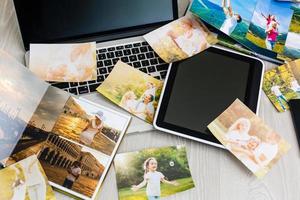 computador portátil em uma mesa com álbum de fotos