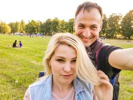 lindo casal jovem fazendo selfie no campo foto