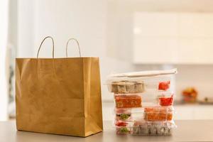 conjunto de embalagens de fast-food. caixa de comida de papel, saco de papel marrom em cima da mesa foto