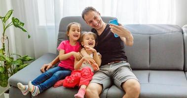 jovem pai com suas filhas bonitinhas tomando selfie foto