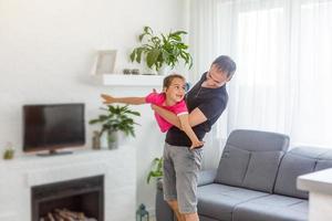 bela e bela foto de pai e filha passando um tempo juntos. ela está voando. seu pai está fazendo a mesma coisa. ambos estão felizes.