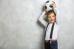 fã esporte menino jogador segurar bola de futebol comemorando feliz sorrindo rindo espaço de cópia de texto livre isolado foto