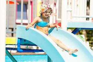 menina deslizando na piscina durante as férias de verão na turquia foto