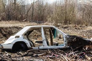 carro quebrado em um lixão no campo foto