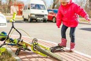 uma garotinha enche um pneu de bicicleta. foto