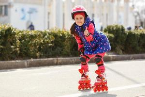 menina bonita de patins no capacete em um parque foto