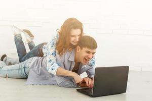 casal comprando online junto com um laptop em um desktop em casa foto