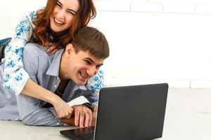 casal comprando online junto com um laptop em um desktop em casa foto