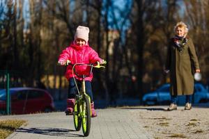 menina andando de bicicleta no parque da cidade. foto