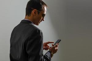 sorridente jovem do Oriente Médio com smartphone foto